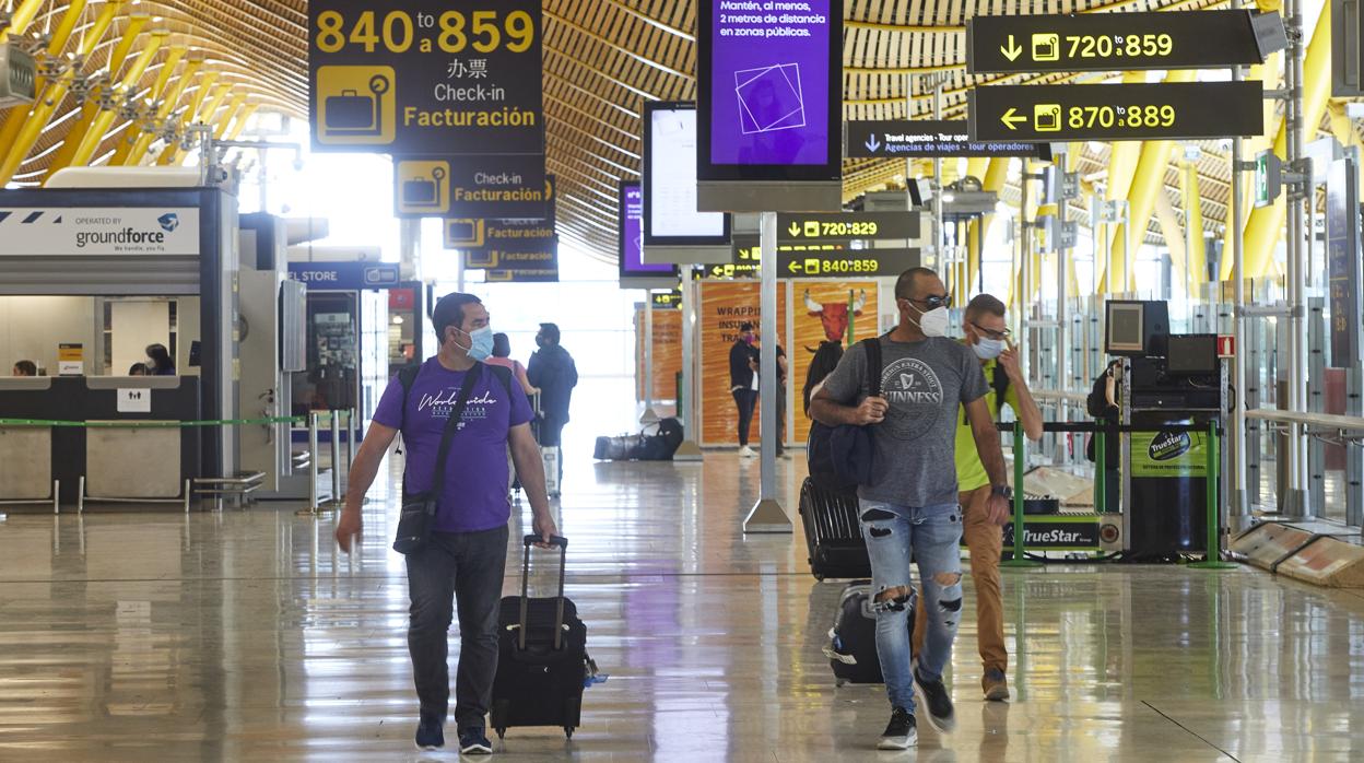 Pasajeros con mascarillas en la T4 de Barajas