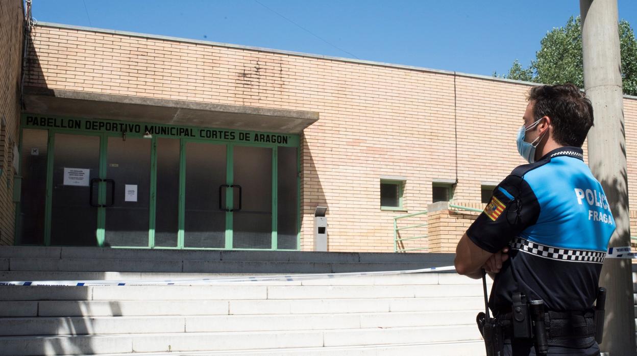 Un policía local vigila el polideportivo de Fraga (Huesca) al que han sido trasladados algunos de los casos de coronavirus detectados en el brote que afecta a Aragón