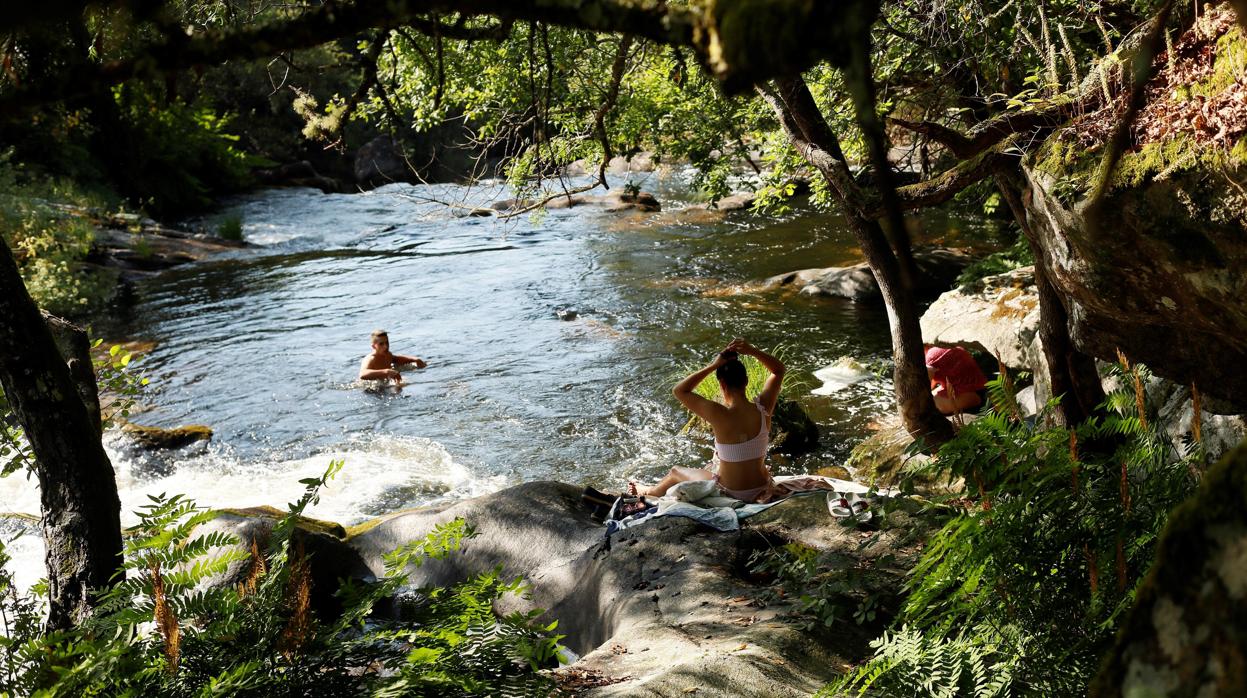 Unos chicos disfrutan de un baño ayer en Los Torrentes do Macara, en Palas de Rei