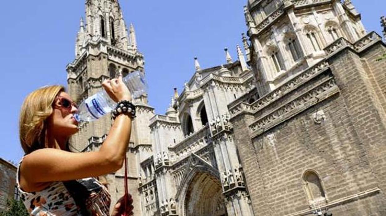 Una turista bebe agua frente a la catedral de Toledo