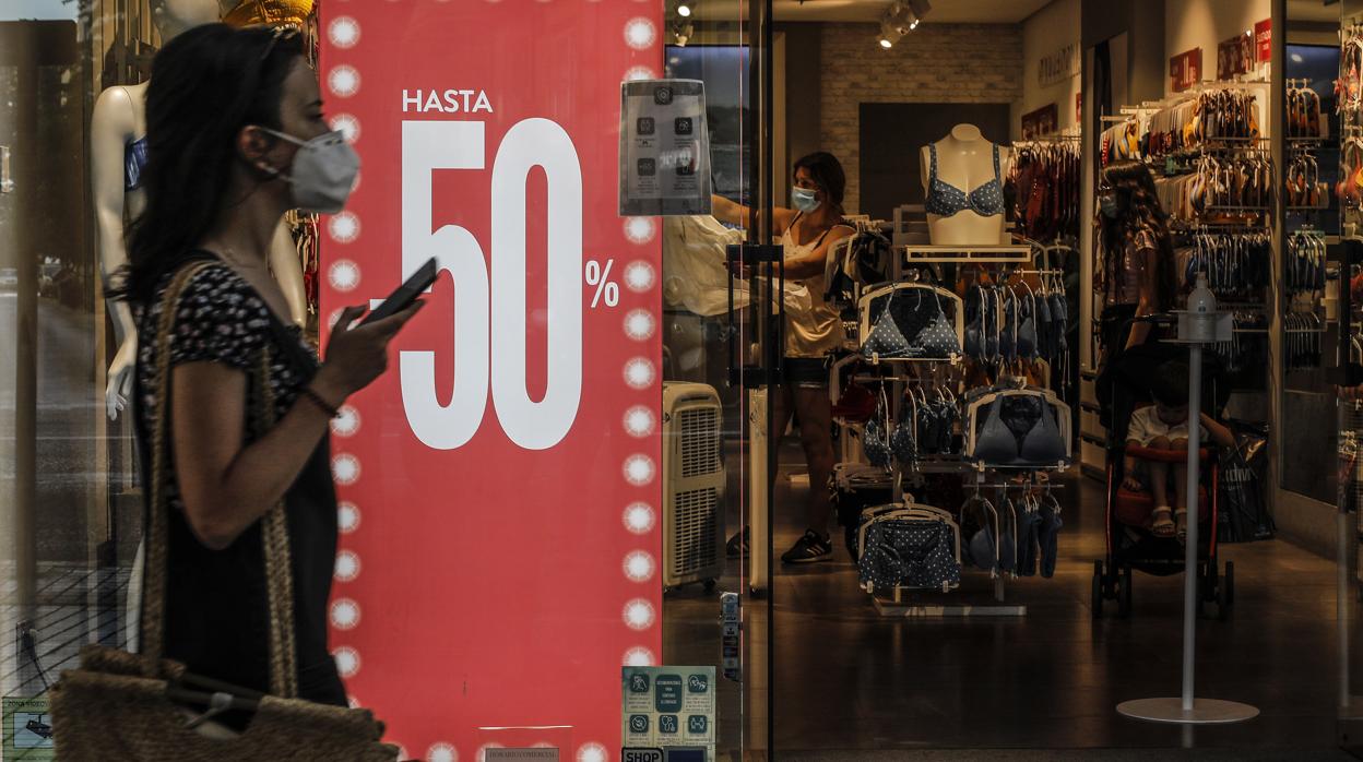 Imagen de una mujer paseando con mascarilla por Valencia