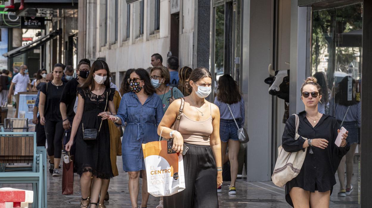 Imagen de personas paseando por Valencia con mascarilla