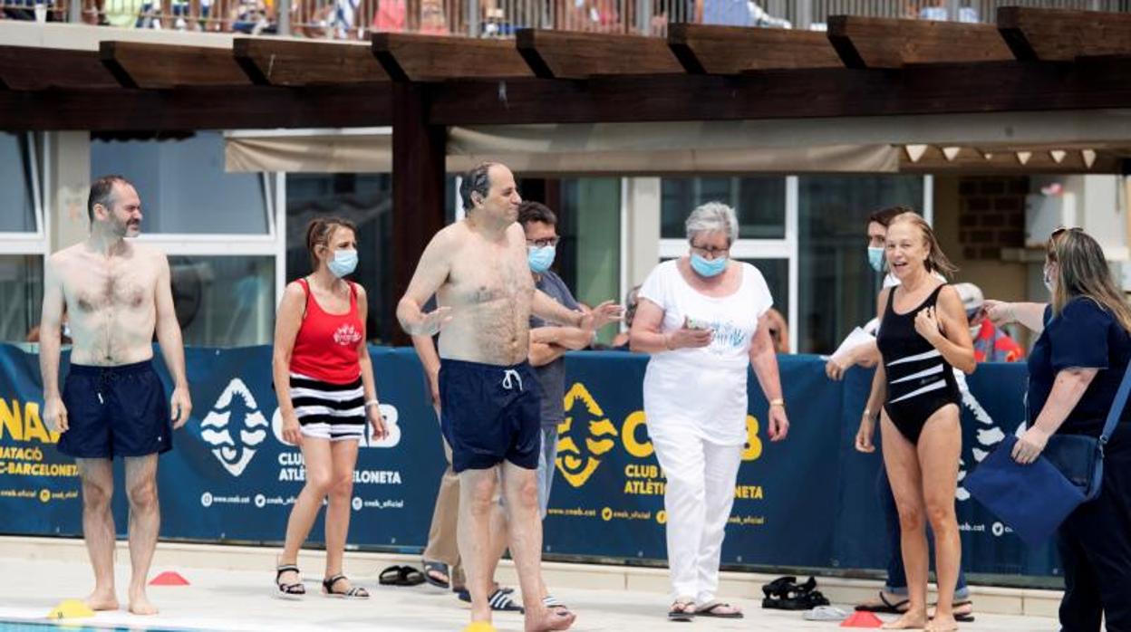 El presidente de la Generalitat, Quim Torra (c), y el vicepresidente del Parlament, Josep Costa (i), asisten a un acto solidario en las piscinas de Barcelona este domingo