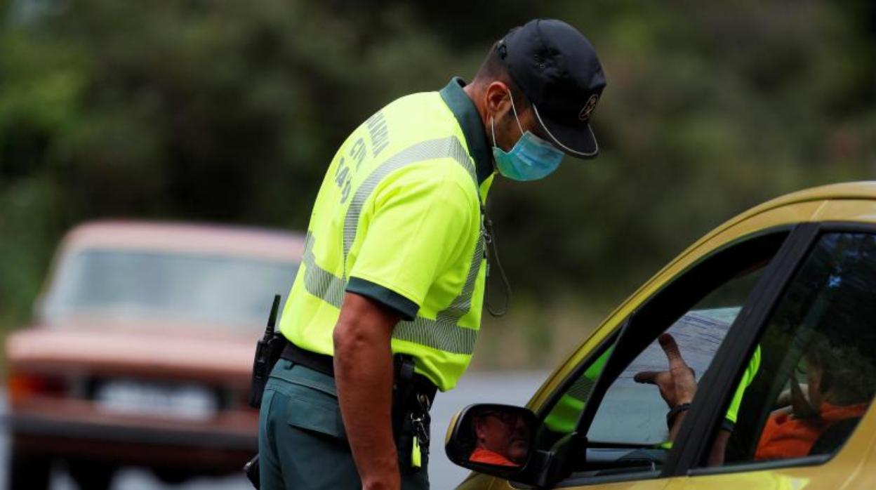 Un agente controla el tráfico protegido con mascarilla