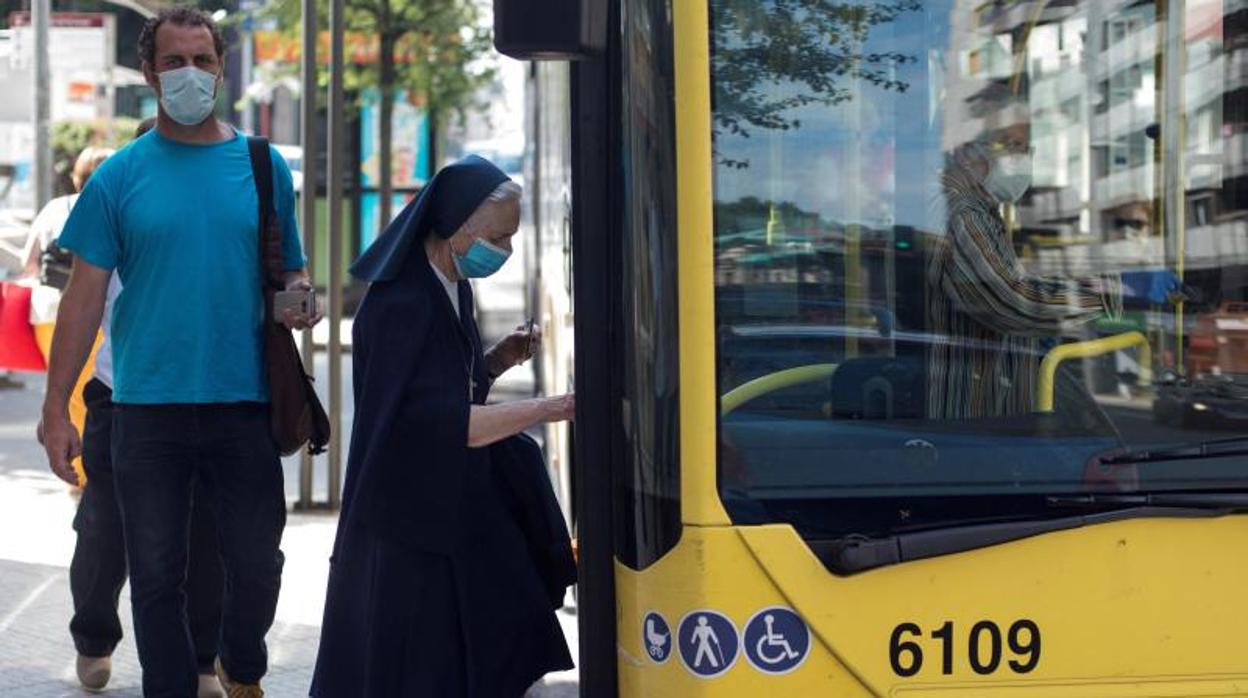 Una mujer, con la mascarilla puesta, accede a un autobús, en una imagen de archivo