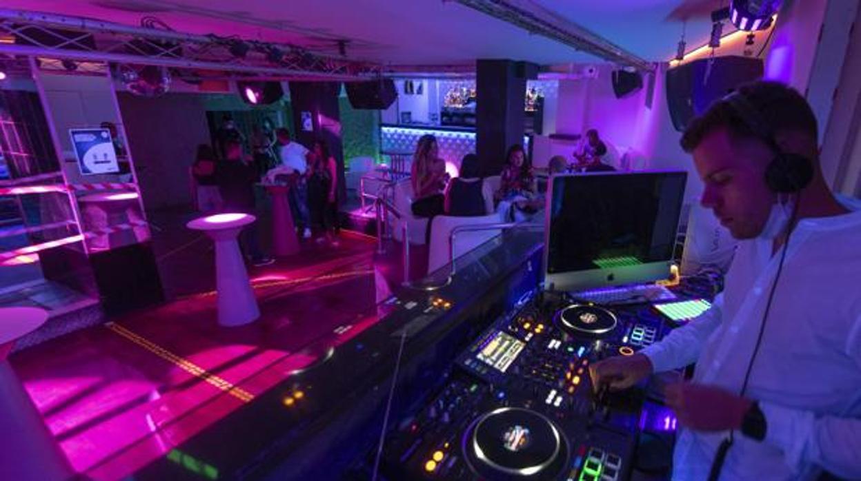 Un Dj pincha canciones en una discoteca