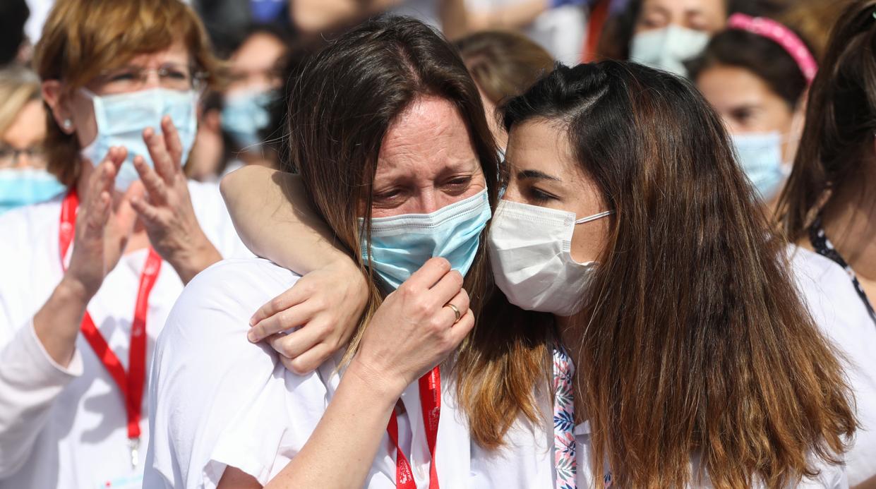 Una profesional sanitaria llora durante la pandemia del coronavirus, consolada por su compañera