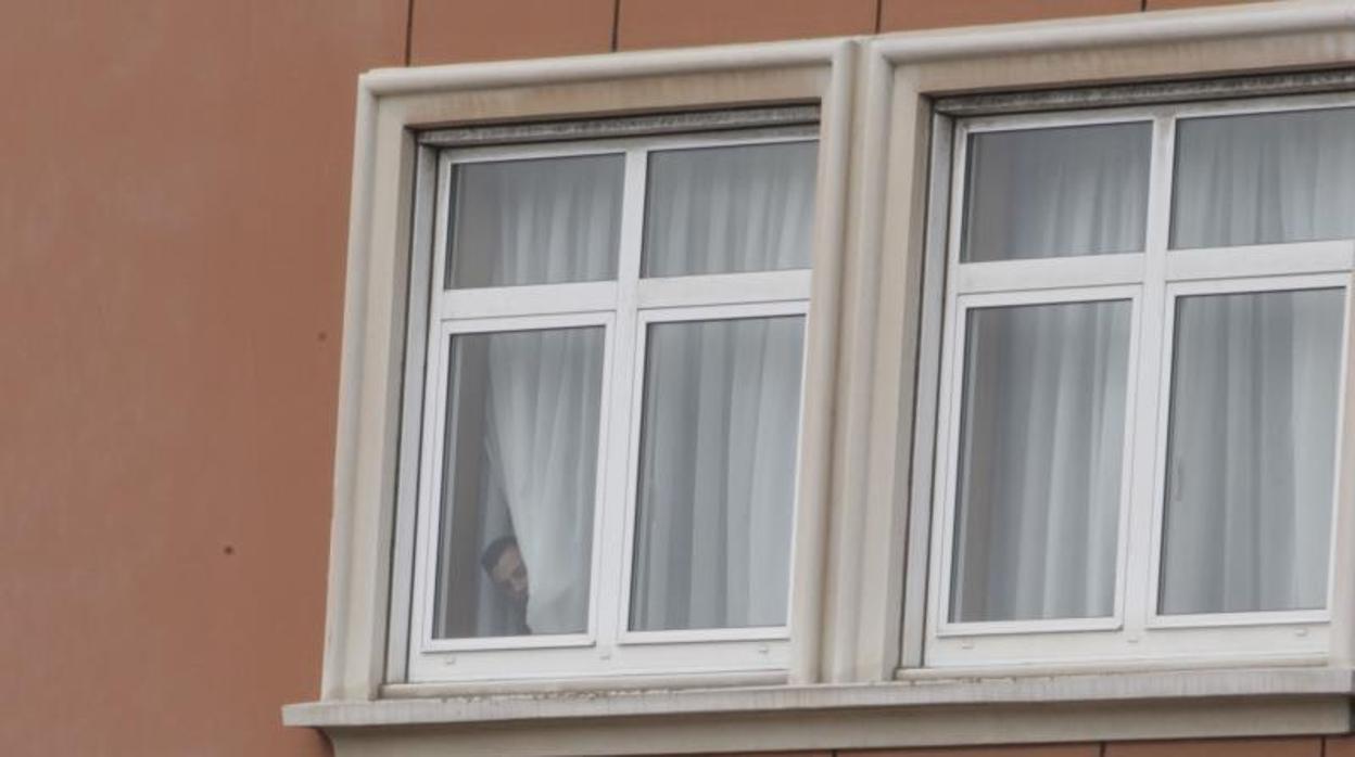 Un jugador del Fuenlabrada observa desde el interior de su habitación en el hotel Finisterre, en La Coruña