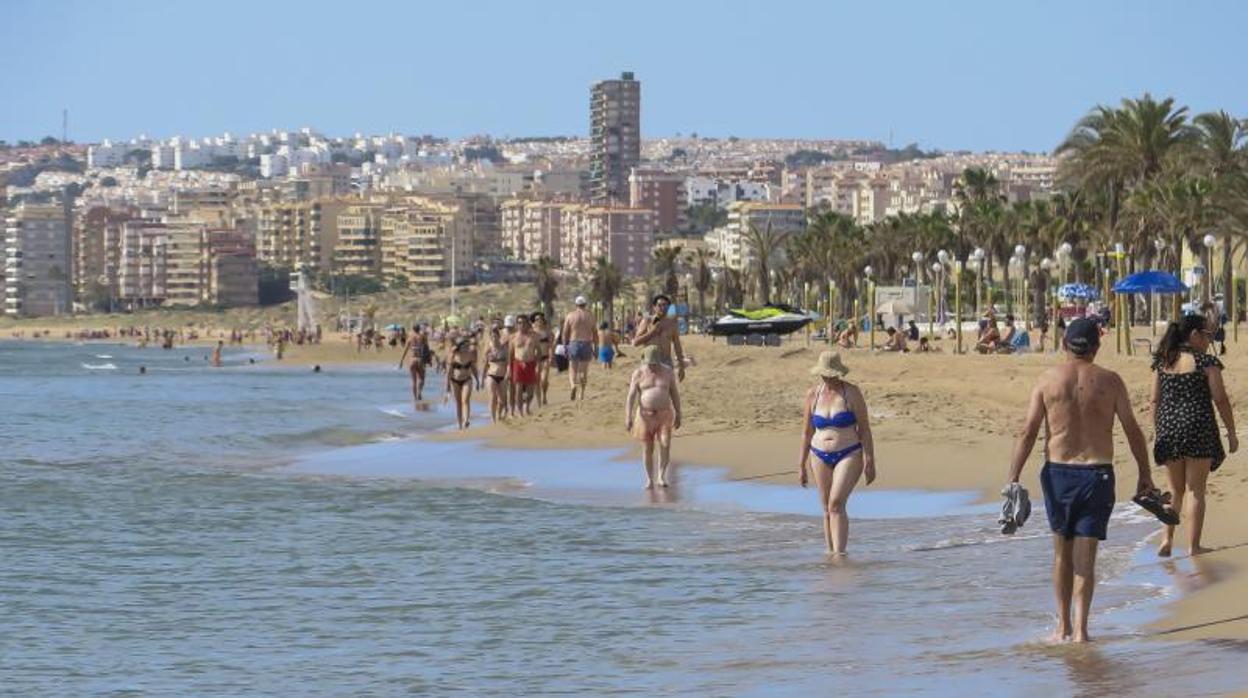 Gente paseando por una playa alicantina