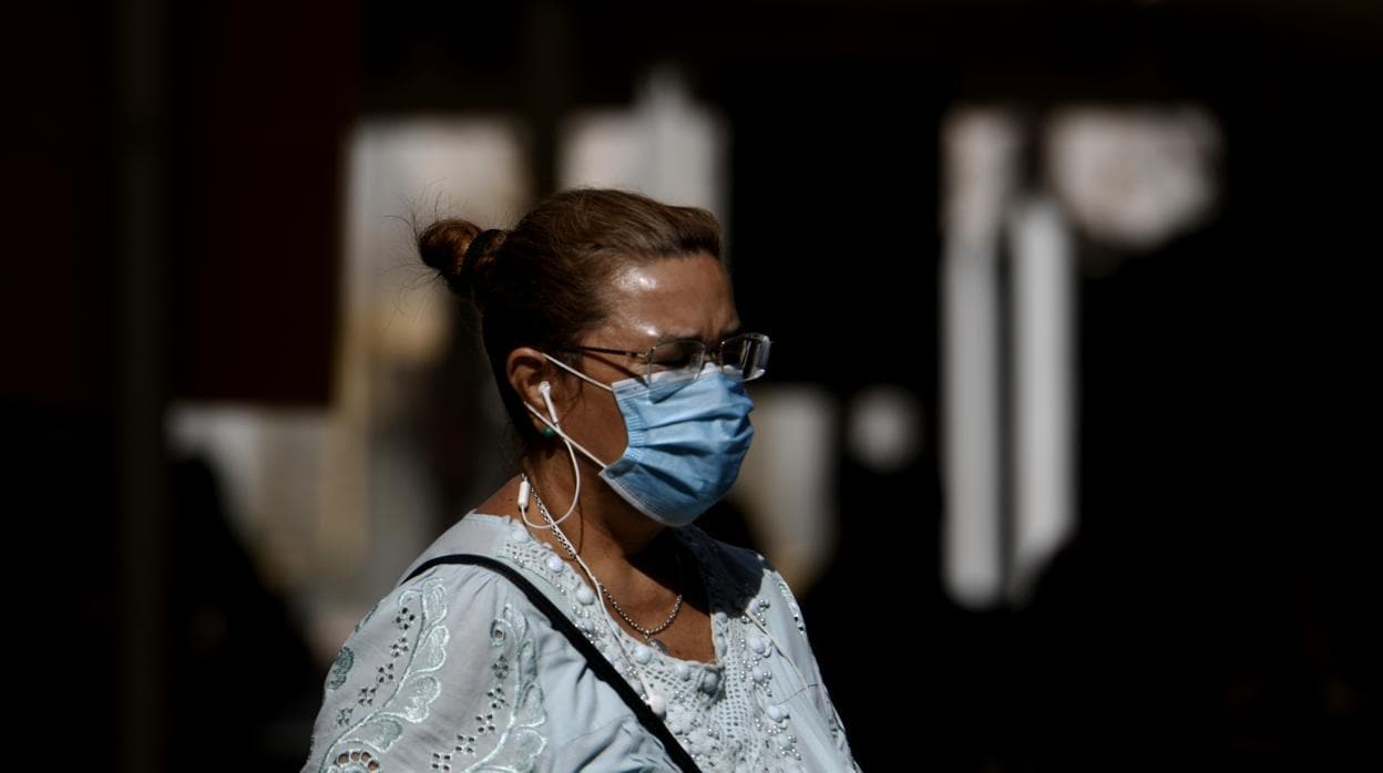 Una mujer camina con mascarilla por Madrid