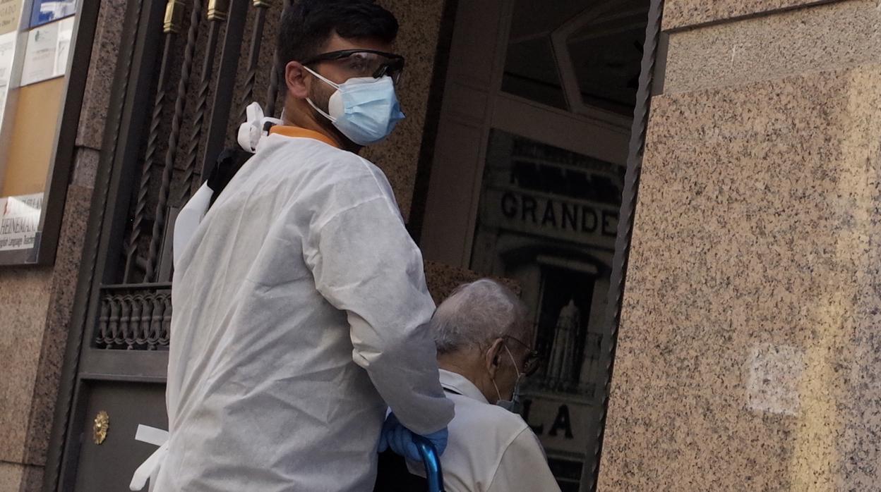 Un sanitario recoge a un paciente en su domicilio, en el centro de Zaragoza