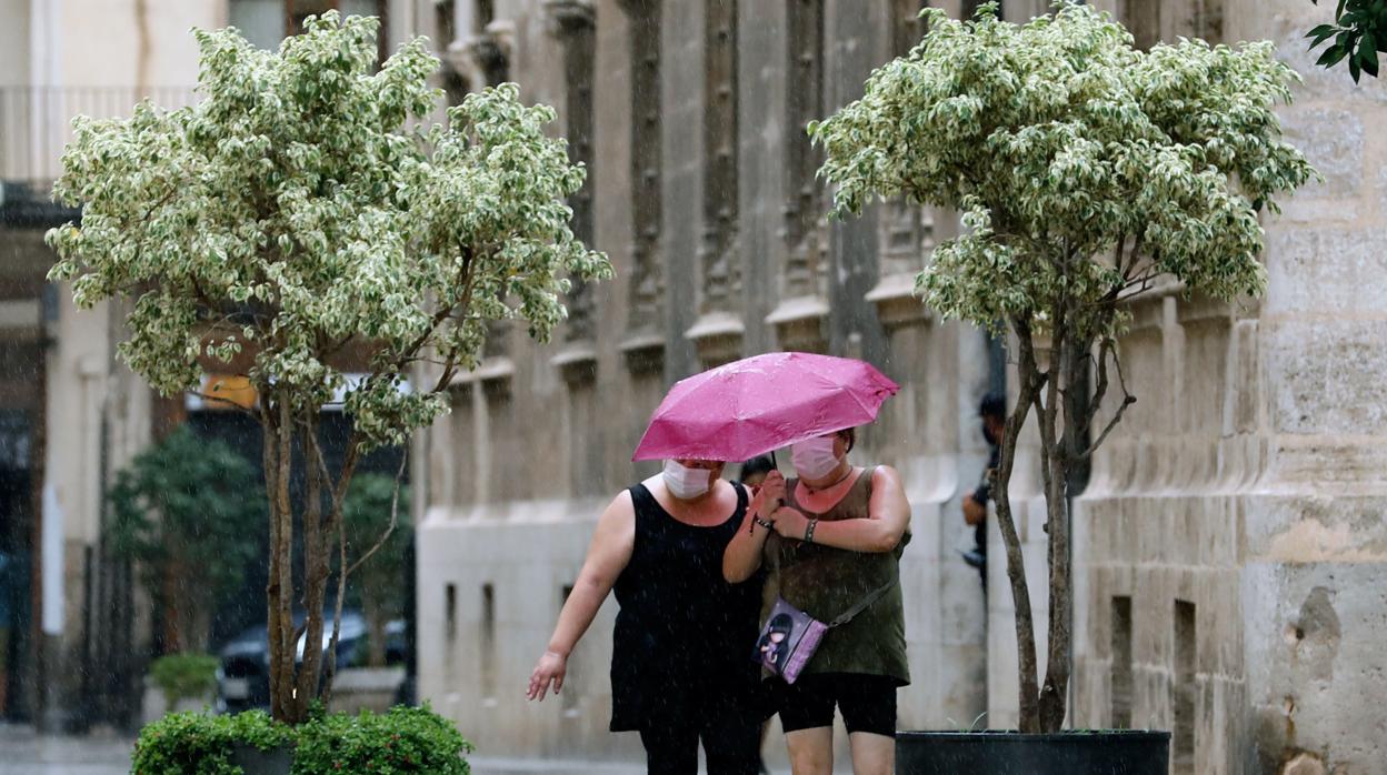 Dos personas con mascarilla caminan por las calles de Valencia durante este lunes