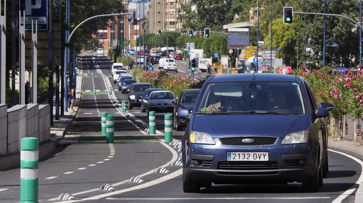 Hilera de coches en el Paseo Isabel la Católica en pleno atasco junto a un carril bici vacío