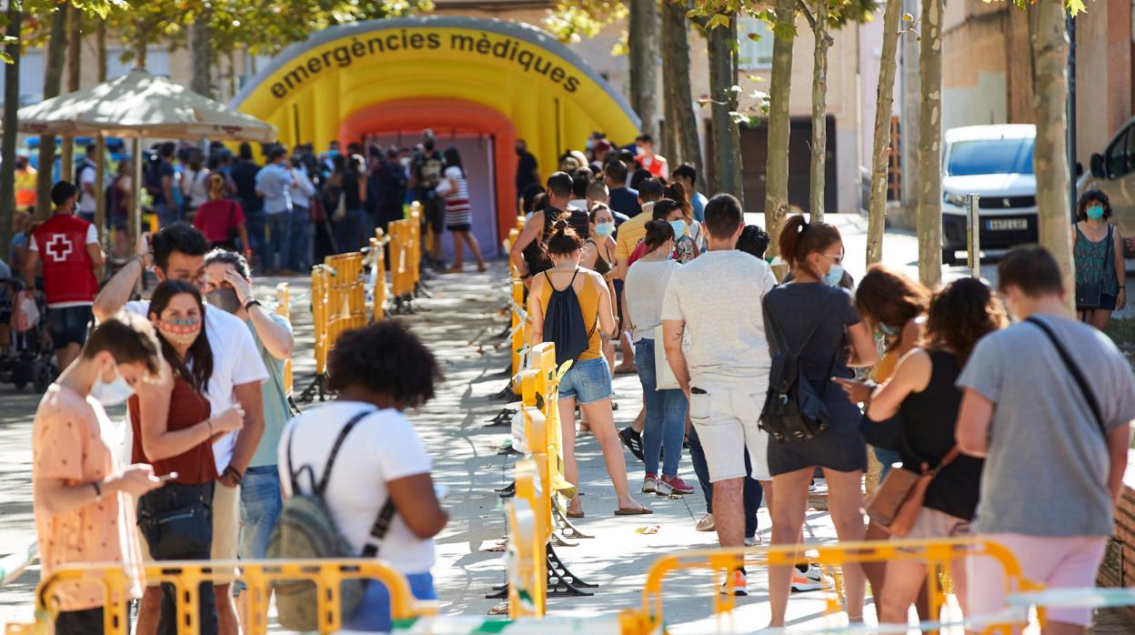 Cola de personas esperando una prueba PCR en Tarrasa (Barcelona)