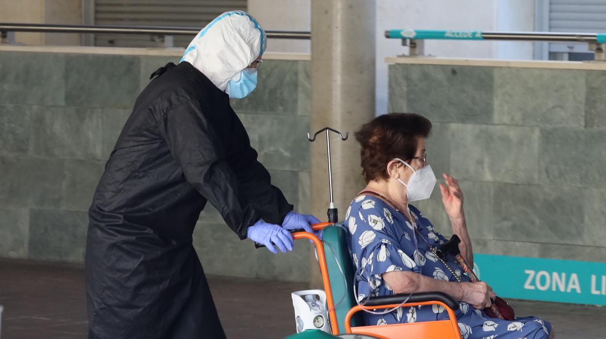 Un sanitario acompaña a una paciente en la zona de urgencias de un hospital de Zaragoza