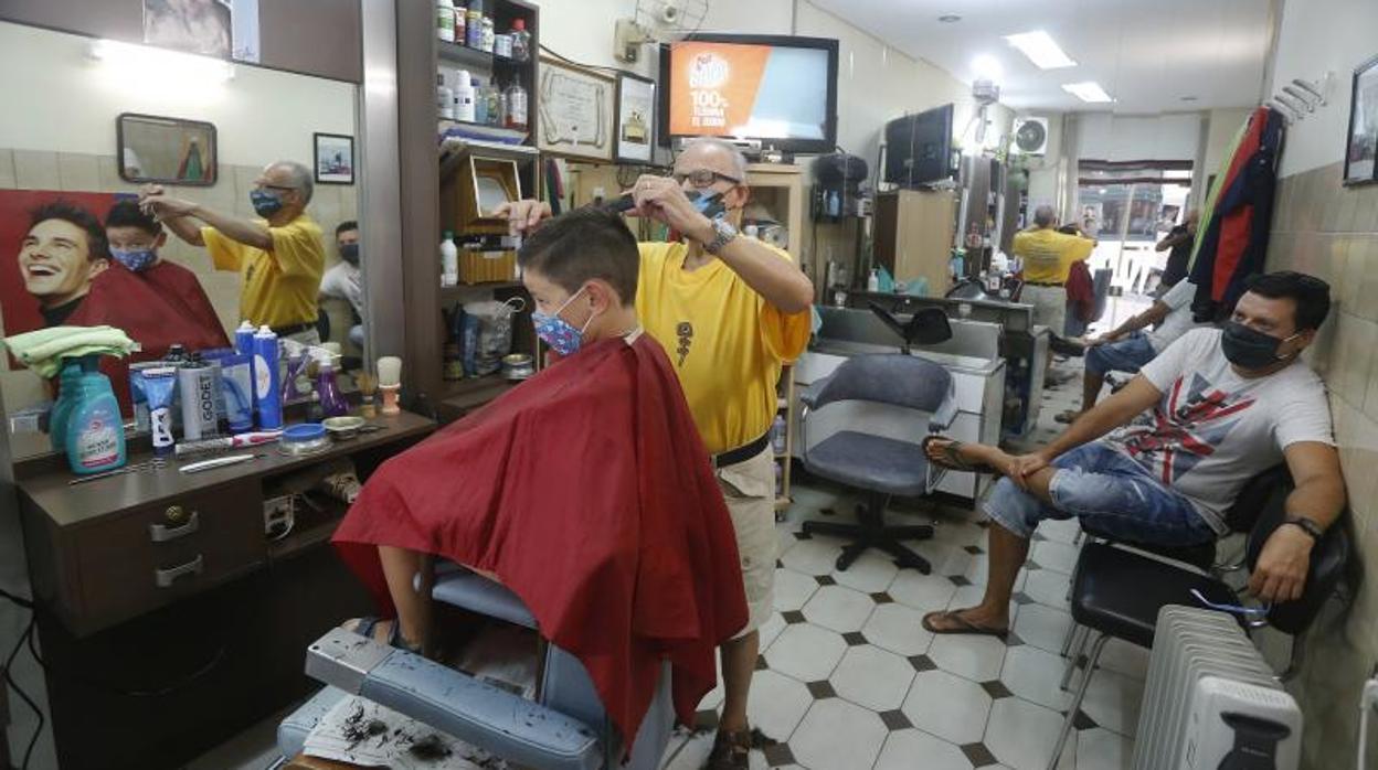 Un peluquero corta el pelo a un niño en Orense, en una imagen reciente