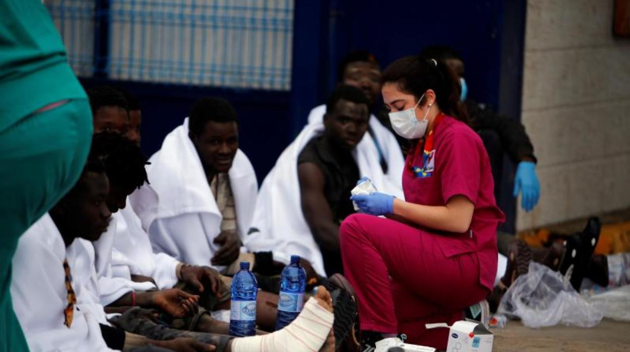 Una sanitaria atendiendo a varios inmigrantes tras otro salto a la valla en abril