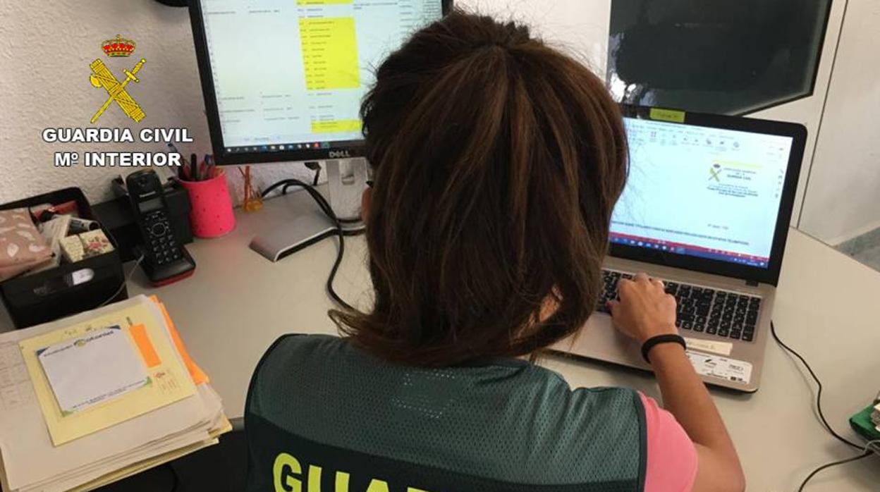 Una investigadora de la Guardia Civil revisando información en Internet