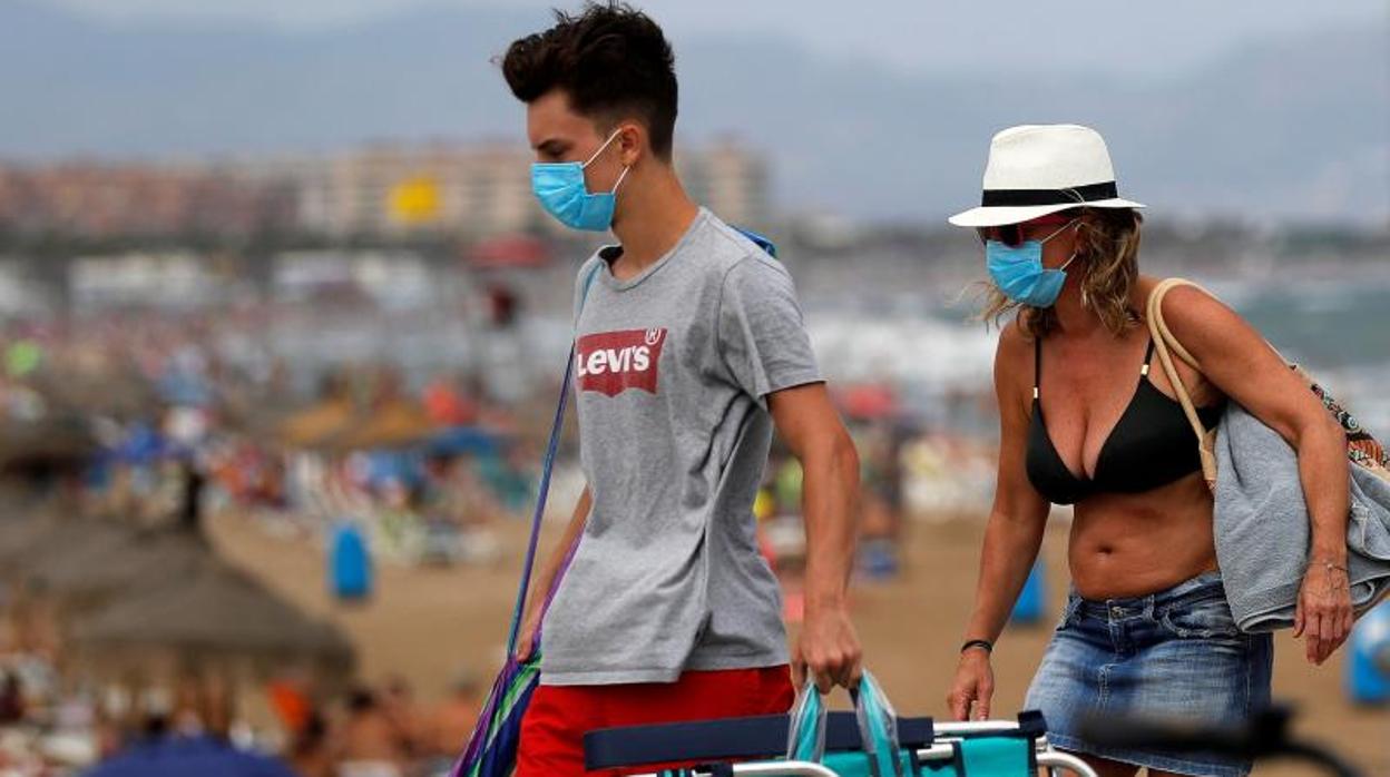 Una pareja se marcha de la playa en Valencia