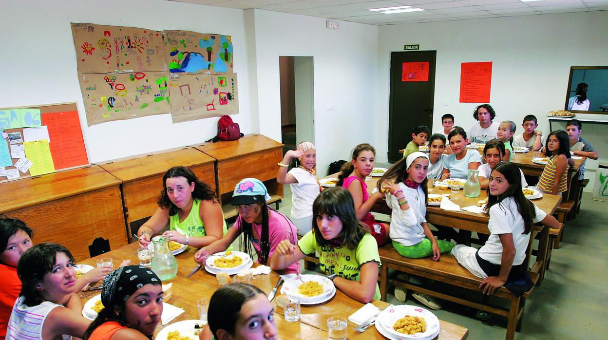 Niños y niñas en el comedor de un campamento de verano