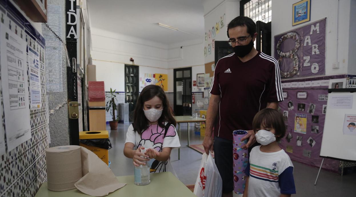 Niños, junto a su padre, en un centro escolar