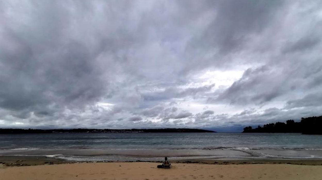 Un hombre sentado frente al mar en una playa coruñesa, en una imagen reciente