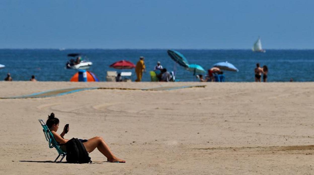 Una joven toma el sol en la playa de Las Arenas de Valencia, este jueves