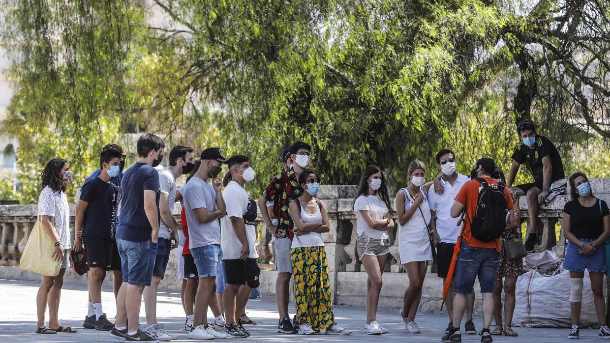 Imagen tomada en agosto en la que jóvenes en Valencia atienden a las indicaciones de un guía turístico