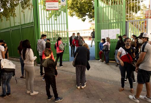 Los padres esperan frente a las puertas del centro a que los niños comiencen la jornada