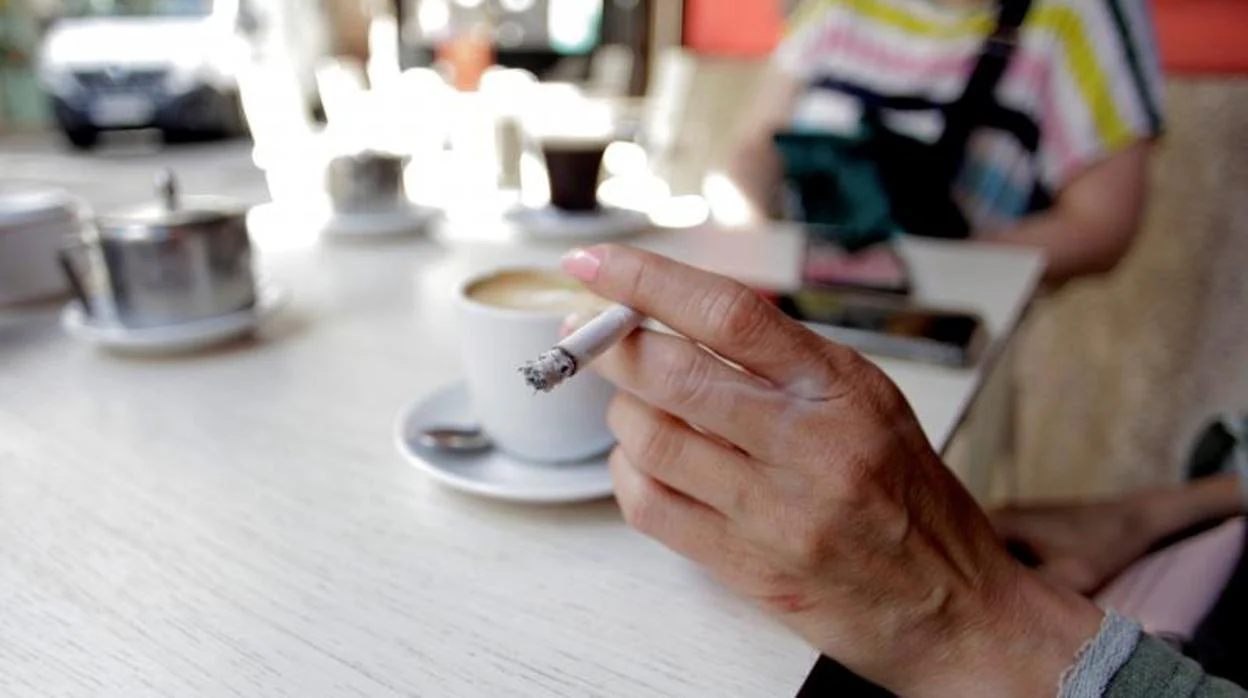 Una mujer fuma en La Coruña en una terraza el 13 de agosto