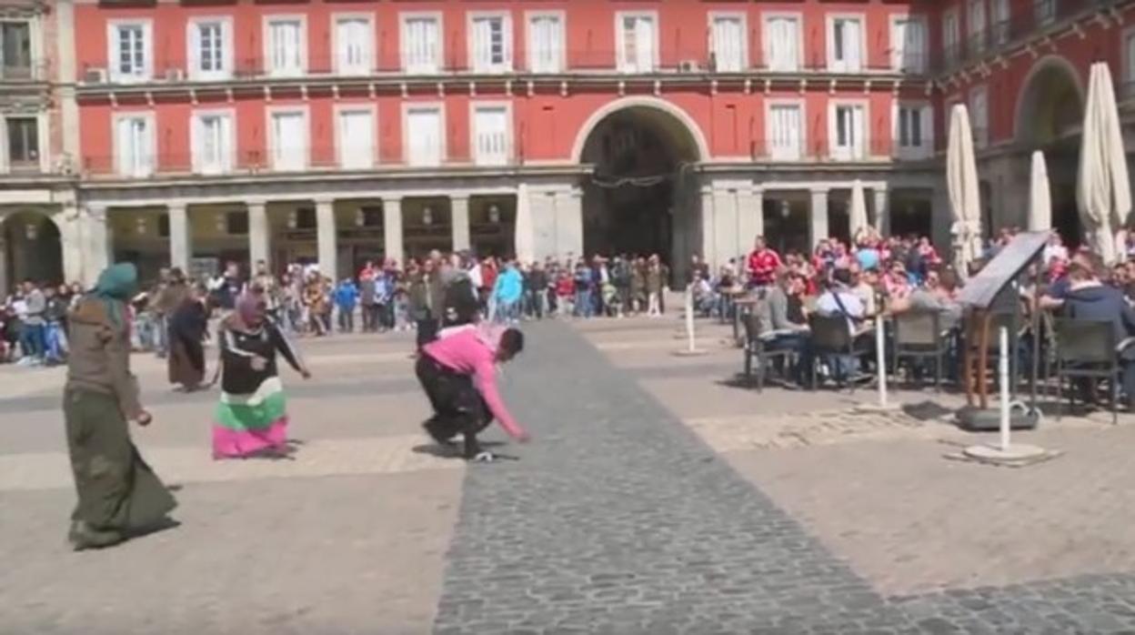 Las indigentes recogen las monedas lanzadas por los hinchas del PSV en la Plaza Mayor