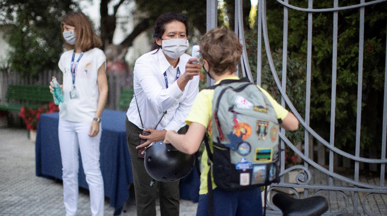 Una trabajadora de la American School de Barcelona toma la temperatura a un alumno