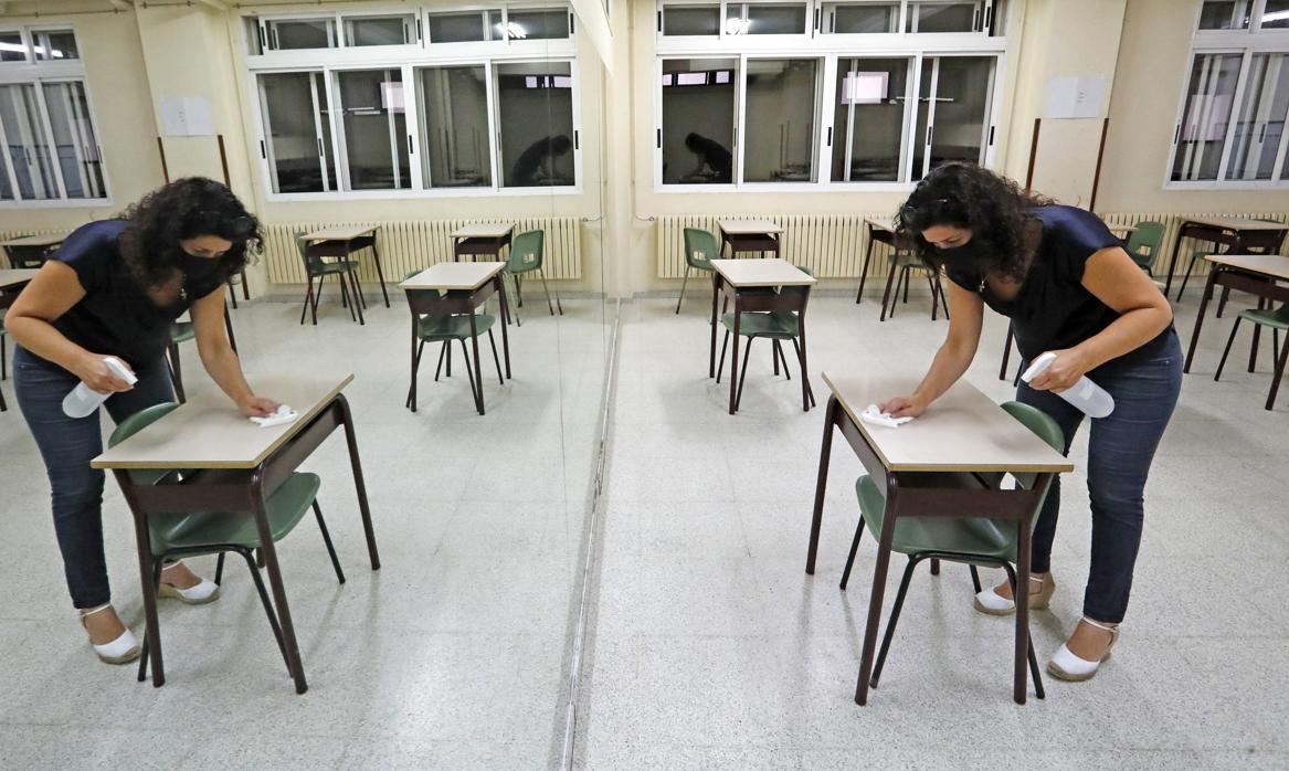 Una profesora de un colegio de Santiago prepara las mesas para el primer día de clases la semana pasada