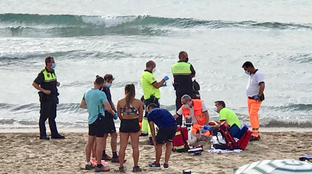 Sanitarios atienden al anciano que ha muerto este miércoles en la playa del Postiguet