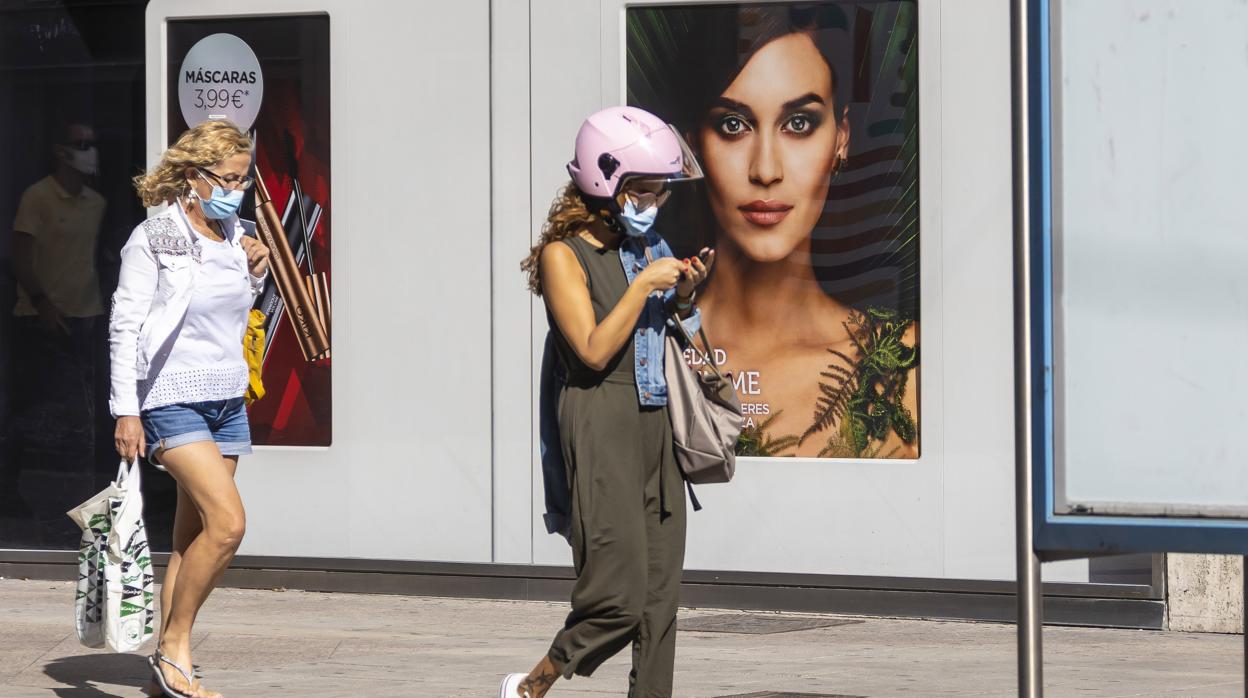 Imagen de dos mujeres paseando con mascarilla por Alicante