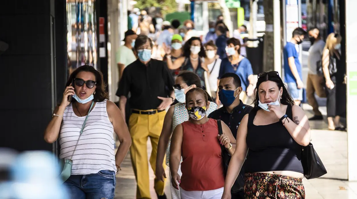 Imagen de archivo de personas paseando con mascarilla en Alicante