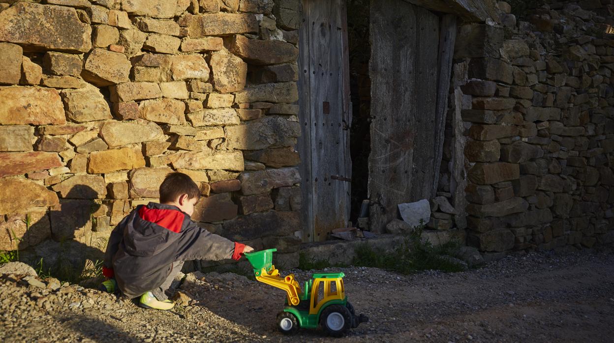 Un niño juega en la calle de un pequeño pueblo soriano