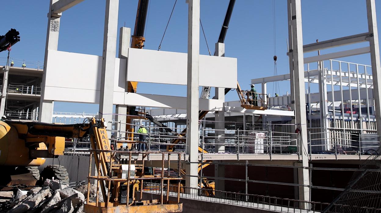 Varios obreros trabajan con maquinaria de construcción en las obras del nuevo Hospital de Emergencias