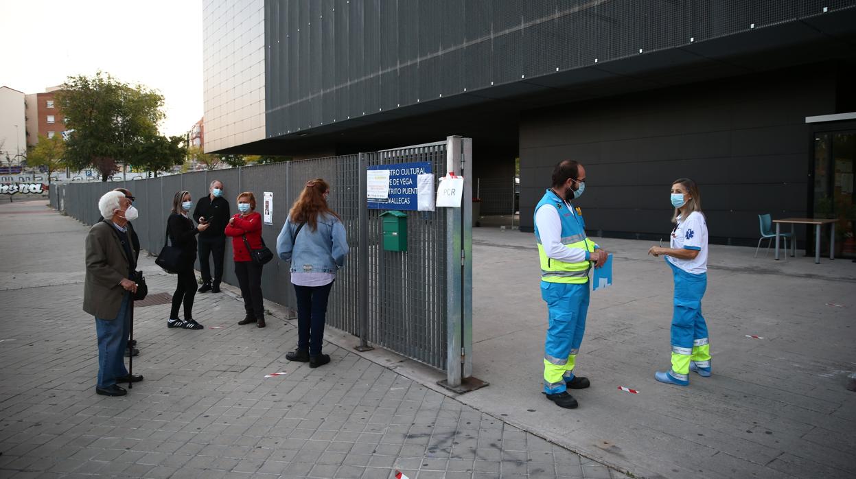 Un grupo de personas espera para los test de antígenos en Puente de Vallecas/ Nueve municipios madrileños afectados por las nuevas restricciones de Sanidad