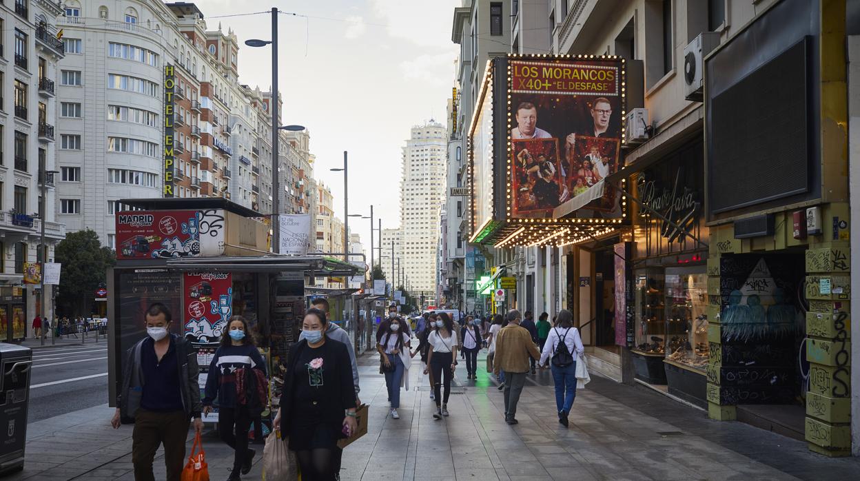 Decenas de transeúntes pasean por la Gran Vía a la altura del Teatro Rialto