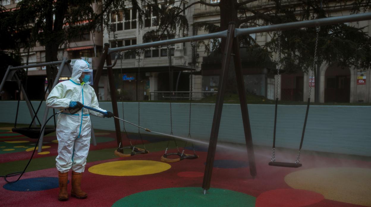 Un operario rocía con desinfectante un parque infantil en Orense