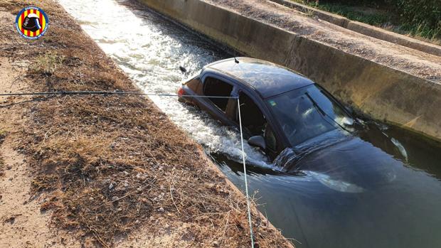 El delicado rescate con cuerdas de una mujer atrapada en su coche sumergido en una acequia en Valencia