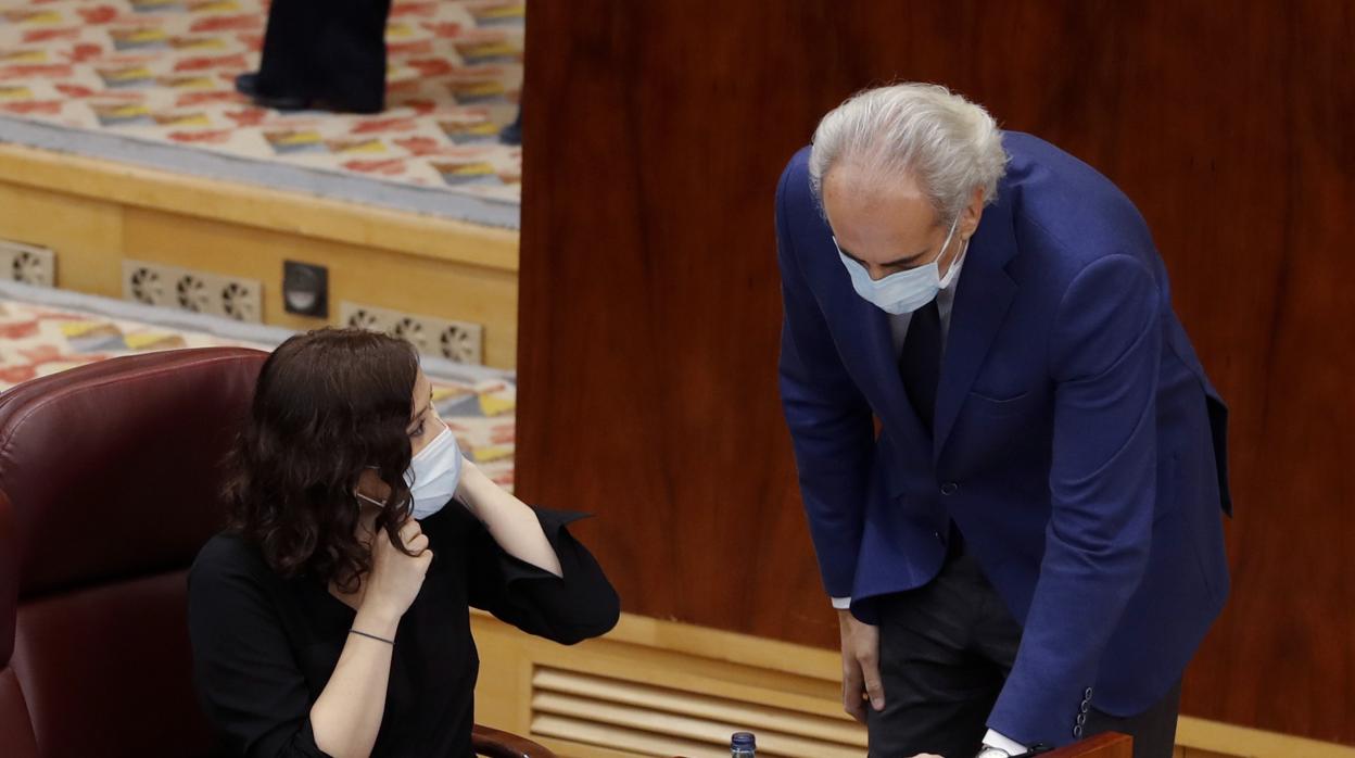 La presidenta Díaz Ayuso y el consejero Ruiz Escudero, departiendo en el pleno de la Asamblea