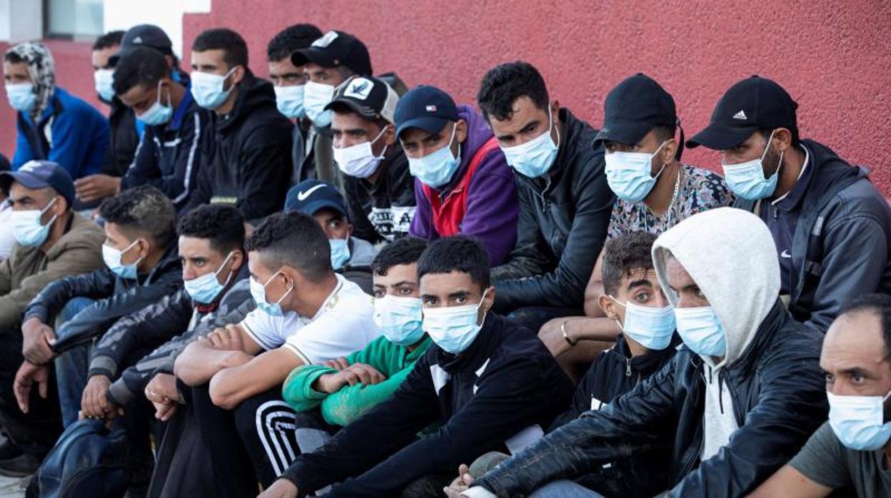 Grupo de inmigrantes haciendo cola en el muelle de Arguineguín