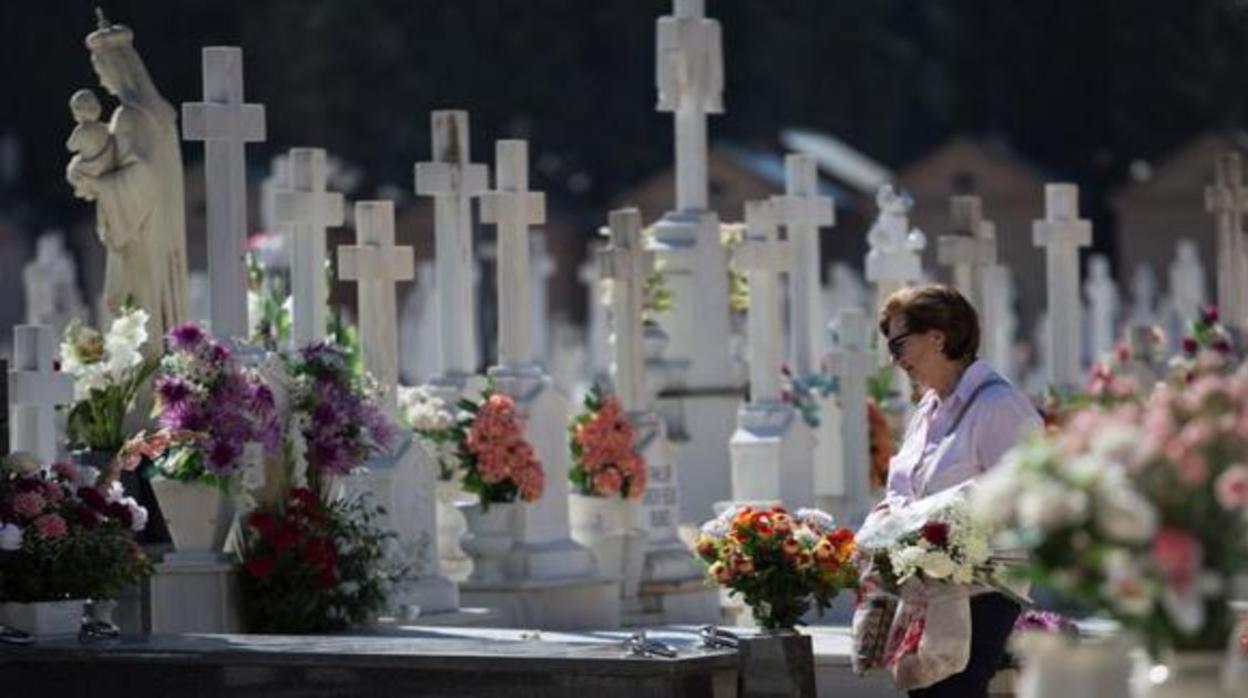 Una mujer junto a una sepultura