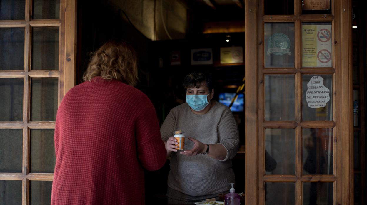 Una camarera sirve café para llevar ante las nuevas restricciones