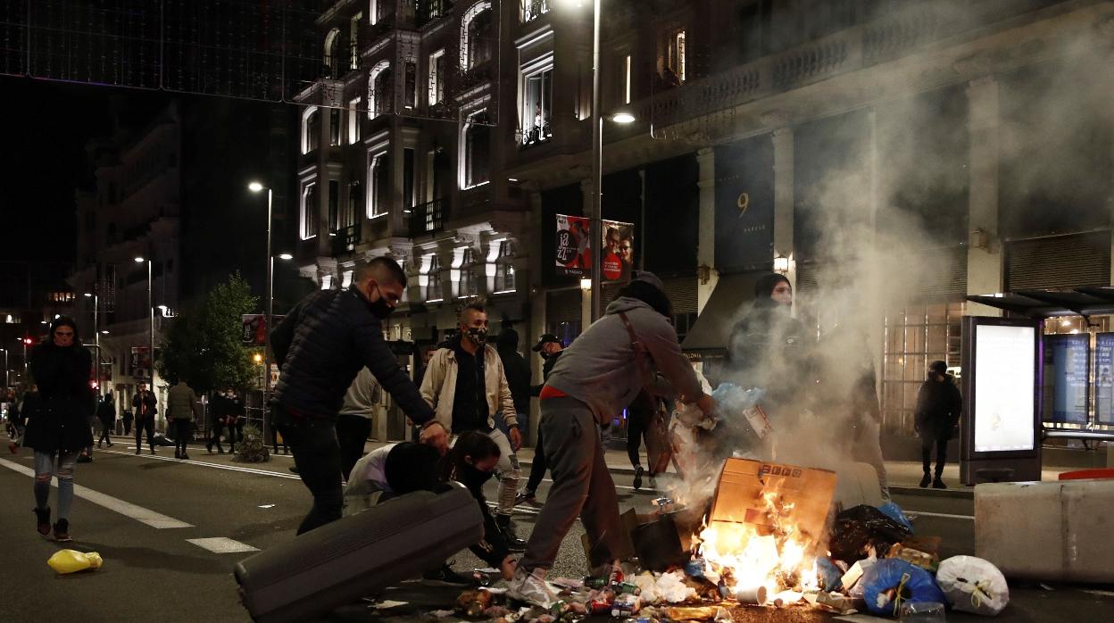 Varios participantes en las protestas convocadas esta noche incendian cubos de basura en la Gran Vía de Madrid, por las medidas tomadas tras el aumento de contagios por coronavirus