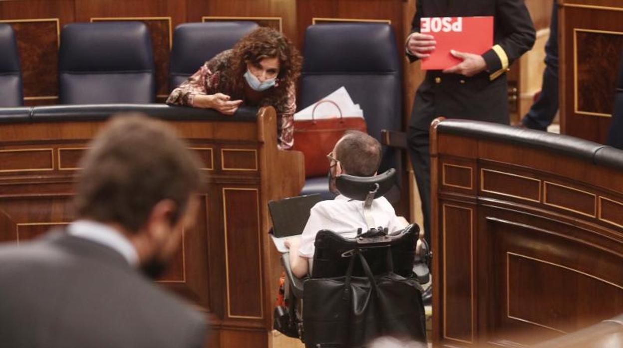 La ministra María Jesús Montero hablando con el diputado de Podemos Pablo Echenique, en el Congreso