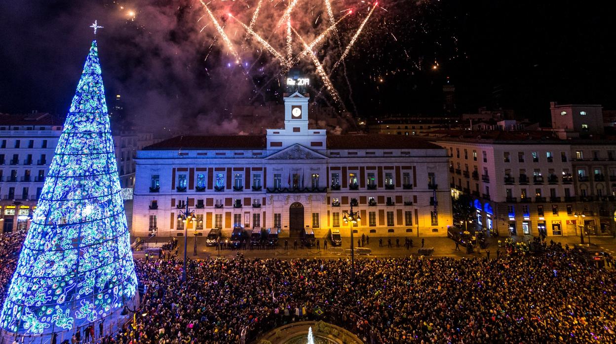 El reloj de la Puerta del Sol da las campanadas de fin de año, frente a la mirada de miles de personas