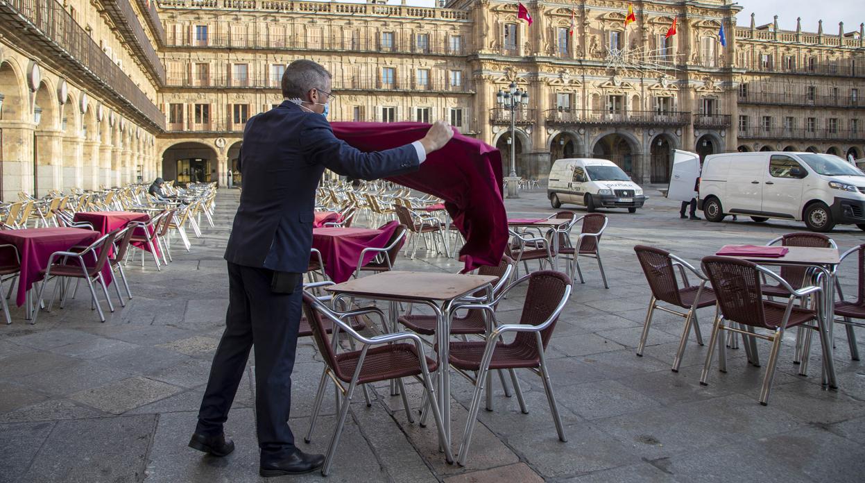 Un trabajador coloca la terraza de un establecimiento hostelero en Salamanca